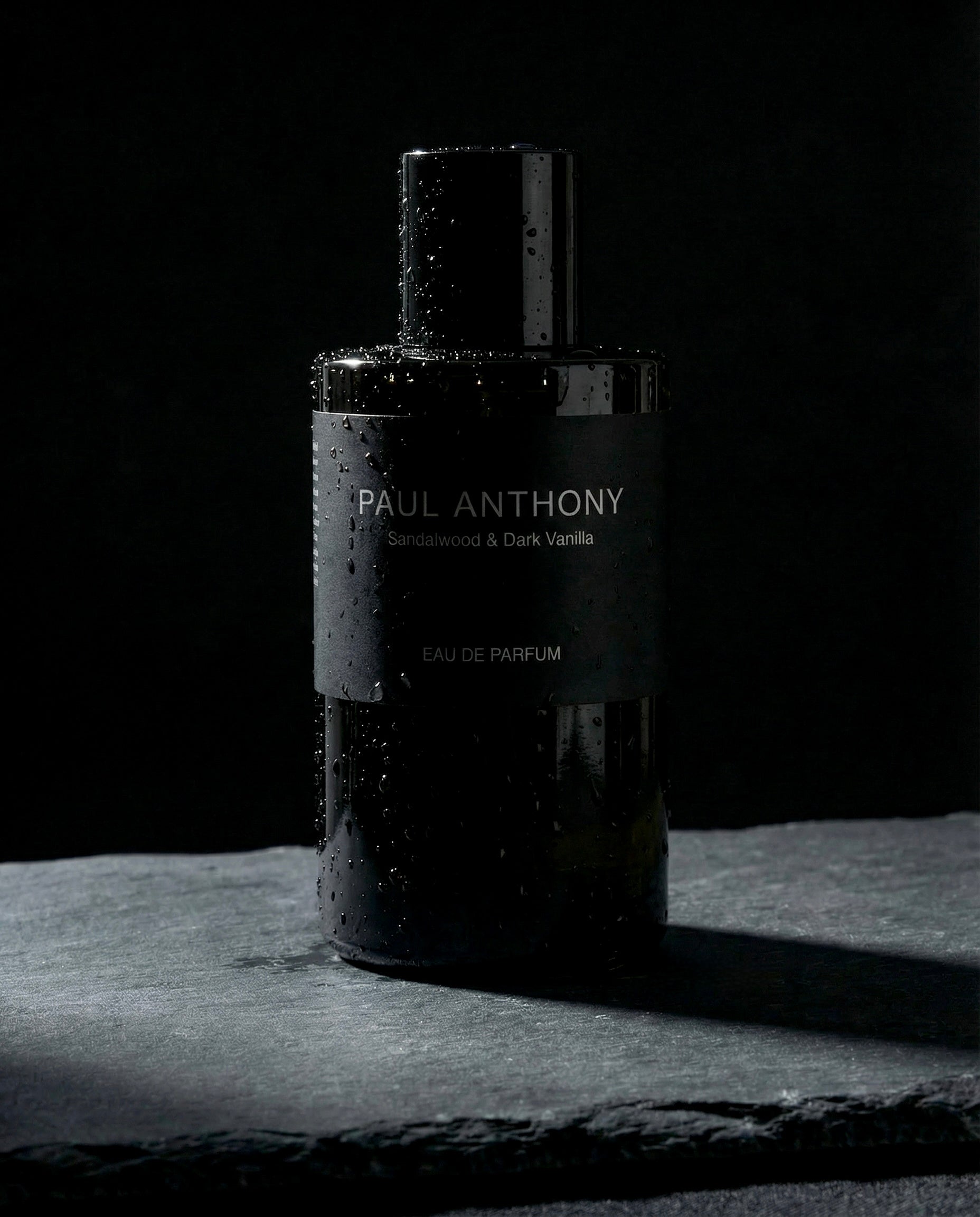 Black perfume bottle labeled 'Paul Anthony' on a dark background. Eau De Parfum made in Australia.