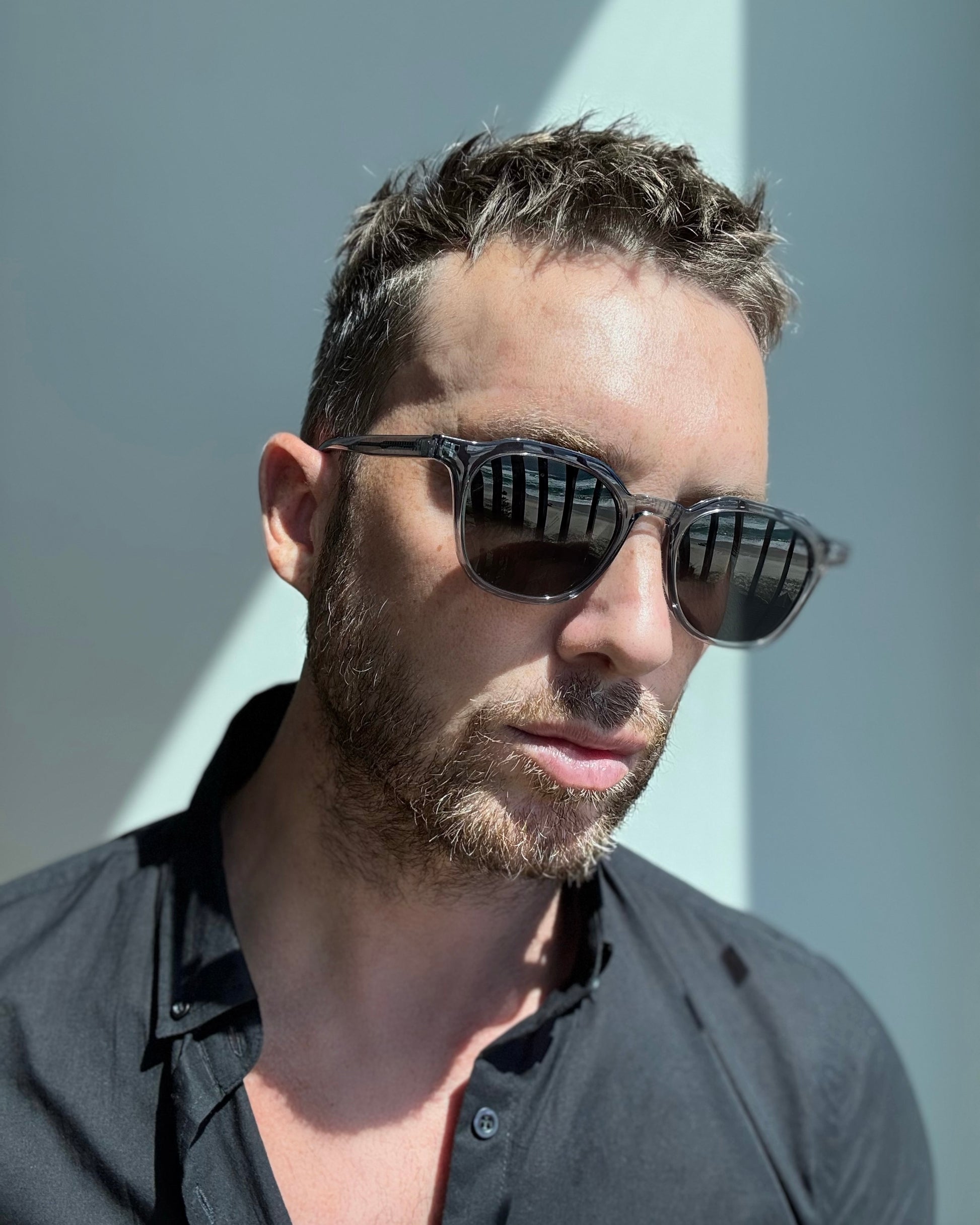 Man wearing sunglasses with a neutral background