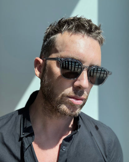 Man wearing sunglasses with a neutral background