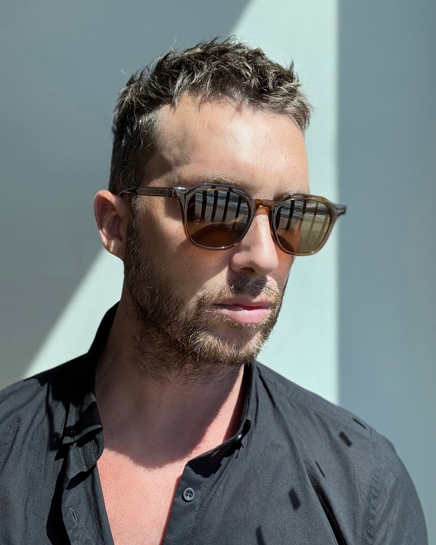Man wearing sunglasses with a neutral background