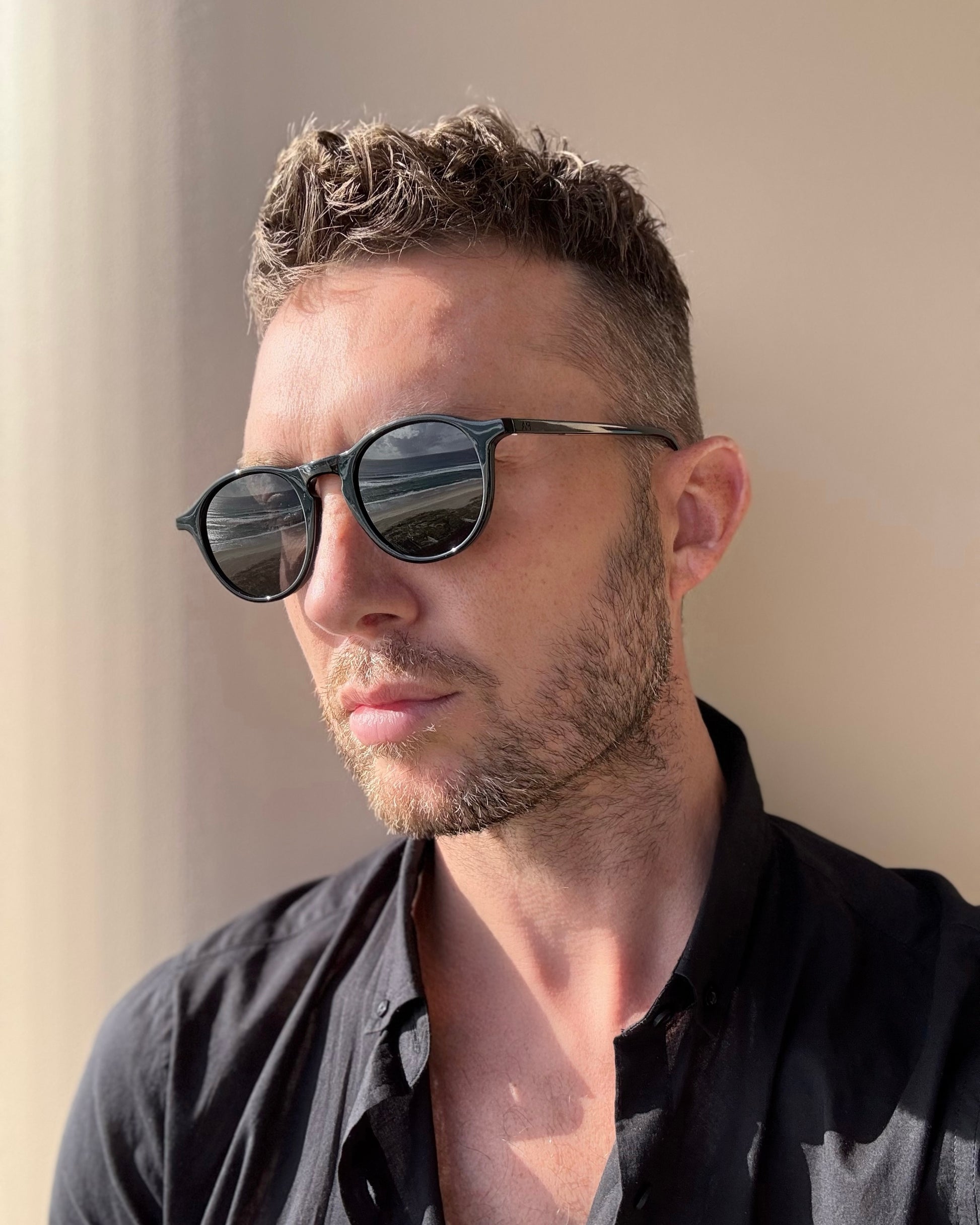 Man wearing sunglasses with a neutral background