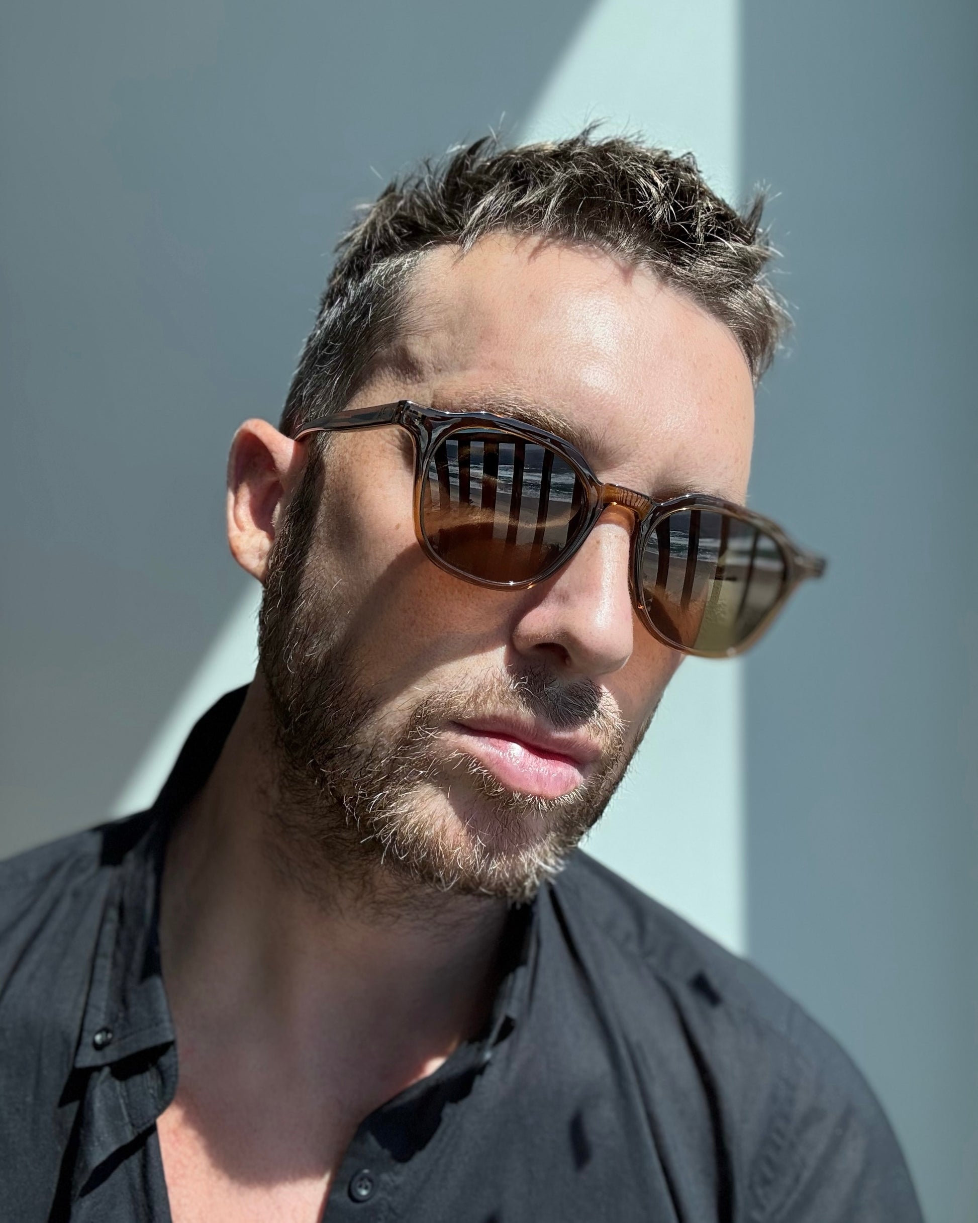 Man wearing sunglasses with a neutral background