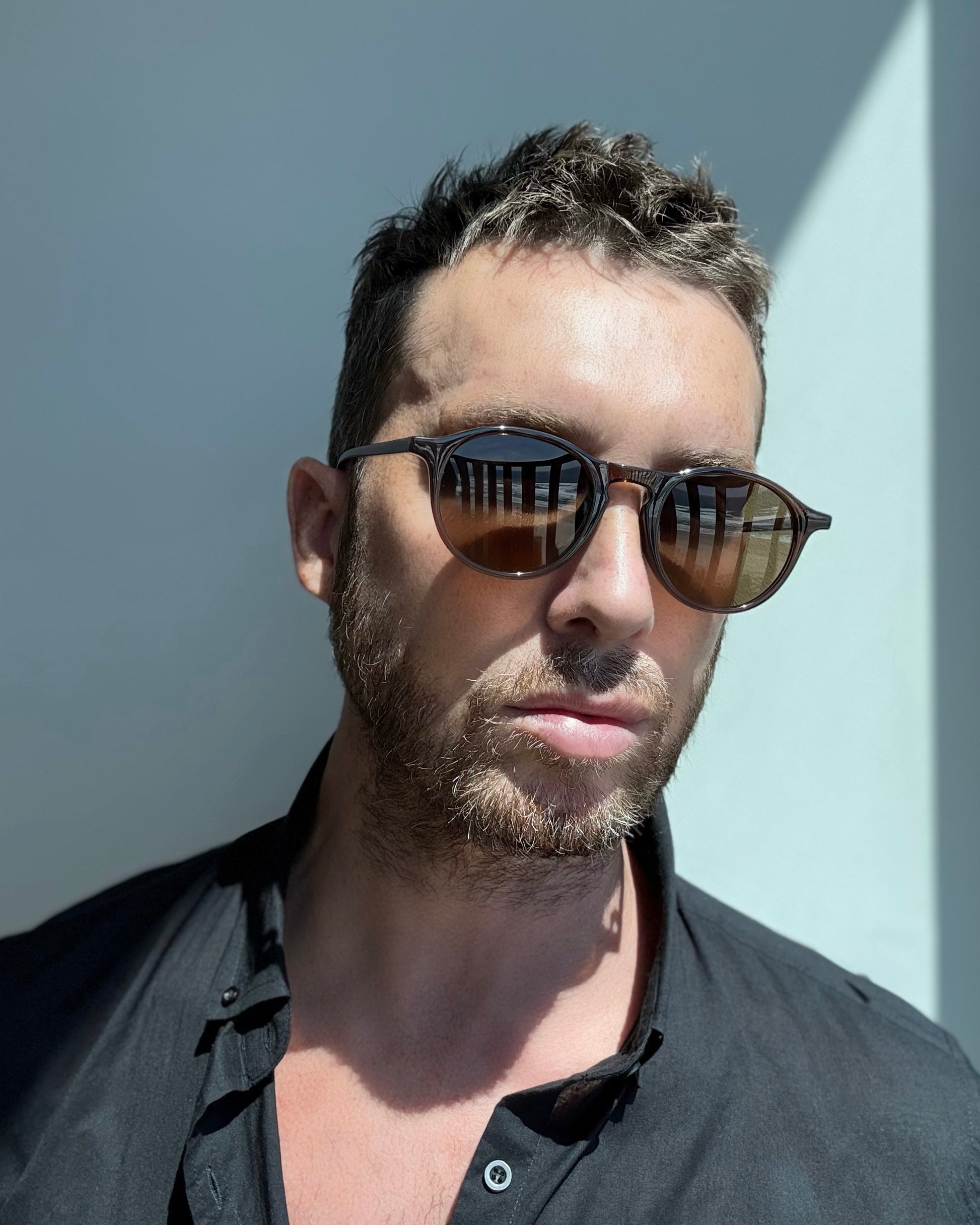 Man wearing sunglasses against a light background